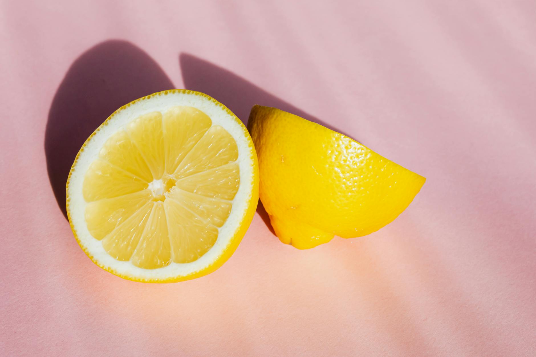 Fresh lemons on a soft pink background, symbolizing renewal and gentle recovery