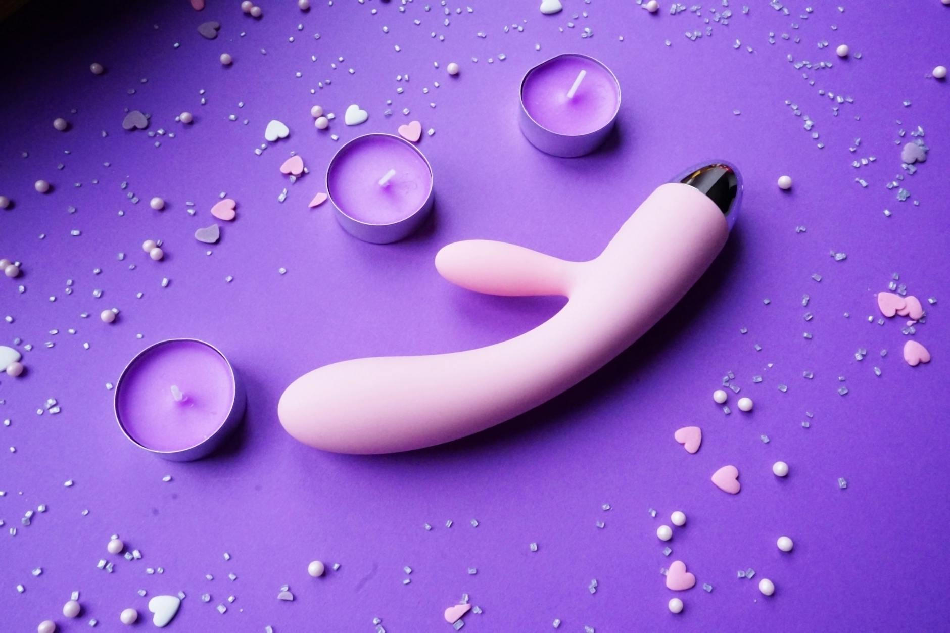 Three colorful vibrators arranged on white fabric, representing shared pleasure in long-distance relationships