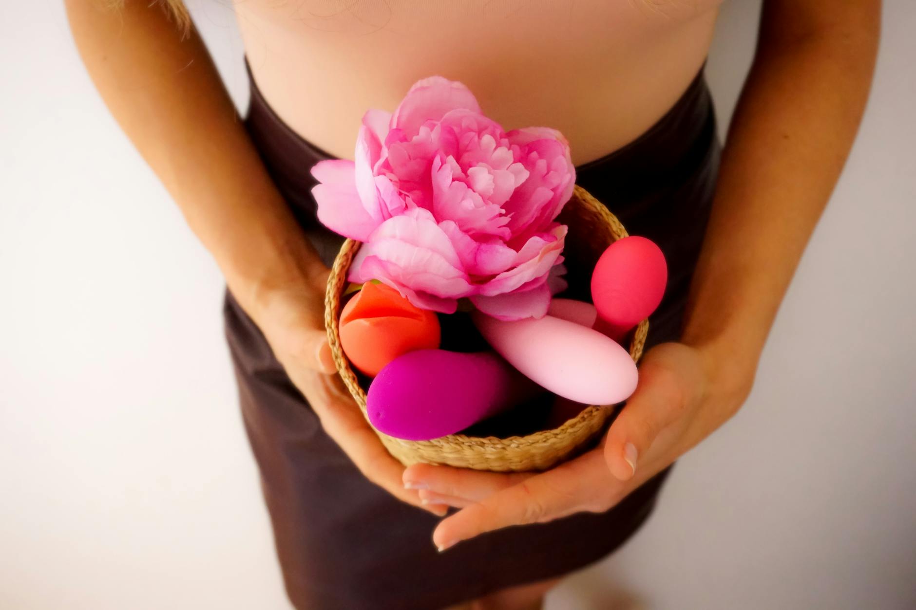 Close-up of hands holding a sleek lemon vibrator in intimate setting