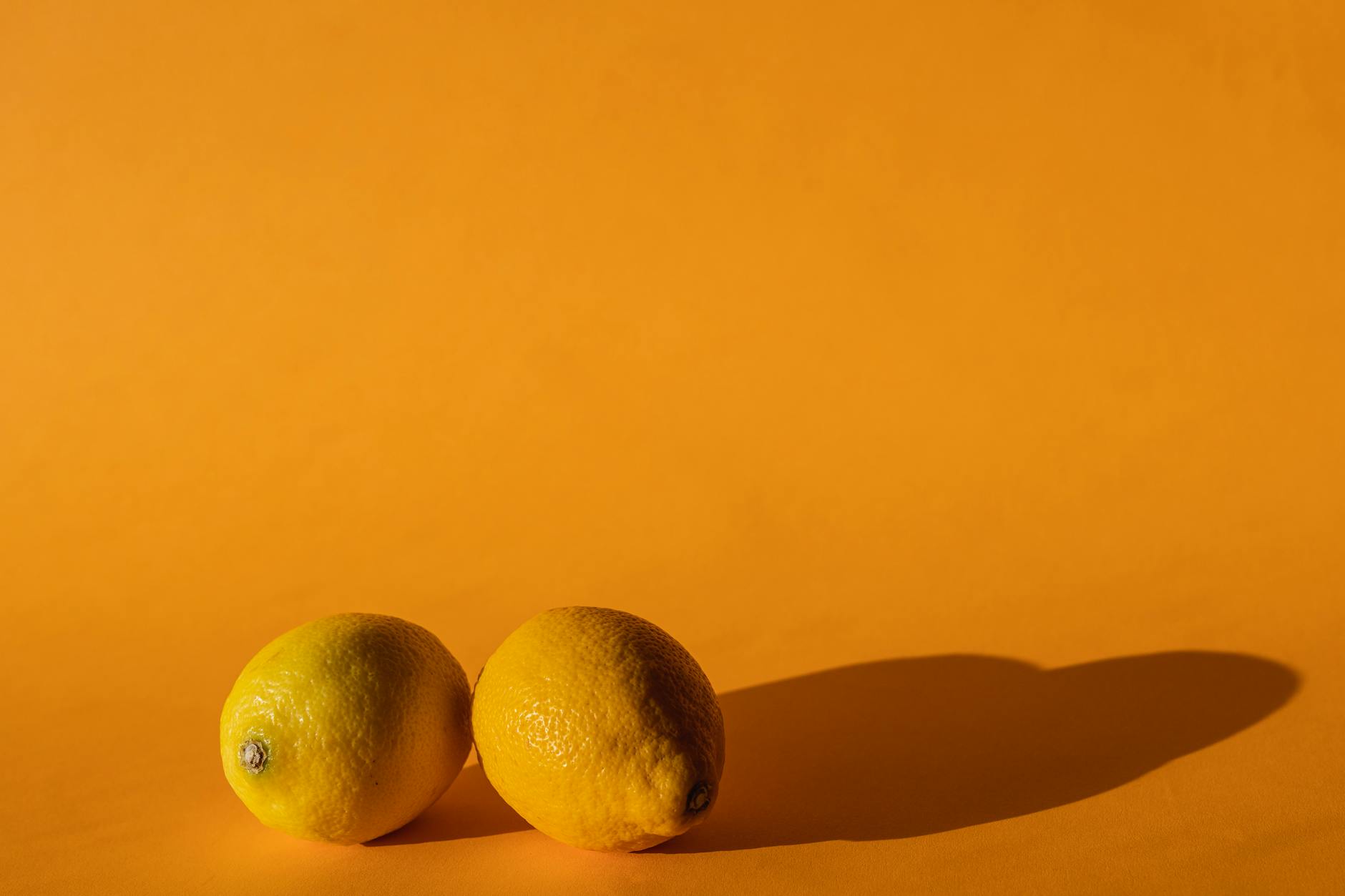 Ripe vivid lemons arranged on a bright yellow background, symbolizing fresh citrus comfort and sensory pleasure